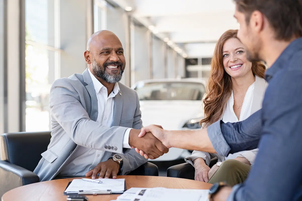 Couple buying a new car at car dealership.