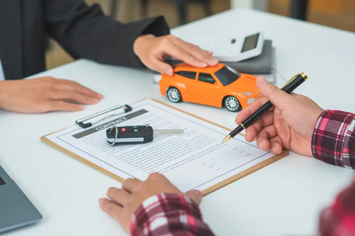 Man signing car insurance document or lease paper.